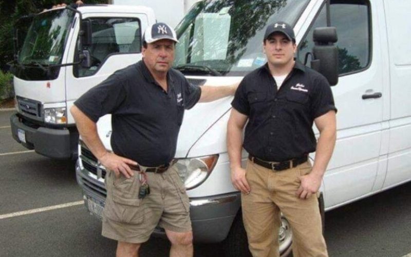 John, owner of Rockland Junk Removal & Hauling, and his dad, standing beside a white work van