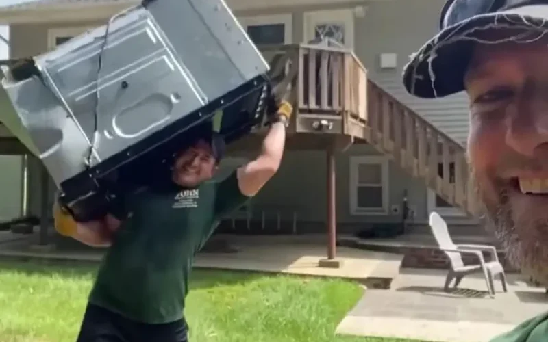 John, the owner of Rockland Junk Removal and Hauling, carrying a large kitchen appliance out of a house for removal