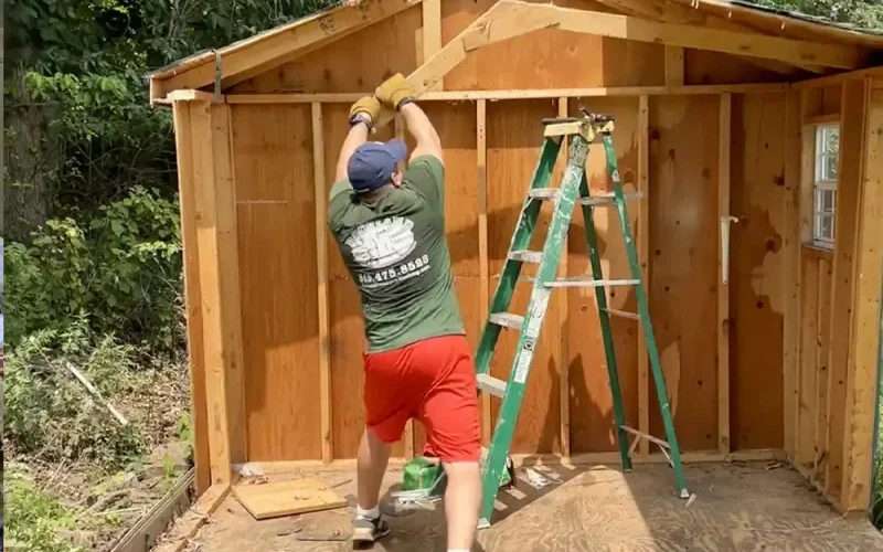 John dismantling a wooden storage shed during an exterior demolition project
